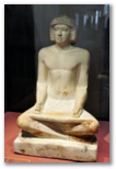 Ancient Egyptian limestone sculpture of a seated scribe at work from the Fifth Dynasty, 2494 to 2345 BC